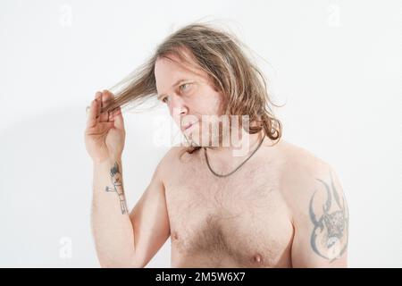 Uomo con la mano sui capelli lunghi Foto Stock
