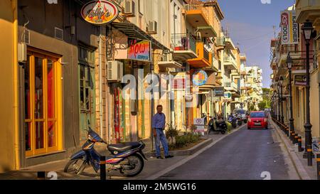 Città vecchia veneziana, strada della città vecchia, ciclomotore, uomo, macchina rossa, lanterne, segni di negozi, case colorate, strada acciottolata, luce del mattino, Rethimnon, centrale Foto Stock