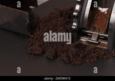 Primo piano del caffè macinato in un macinacaffè. Dettagli sui chicchi appena macinati Foto Stock