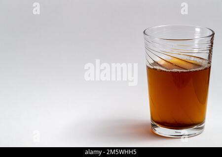 Bicchiere di tè da bevanda con schiuma su uno sfondo chiaro e pulito. Semplice foto da bere. Foto Stock
