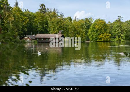 Vecchia casa di legno sul lago Hinterbruehl a Monaco di Baviera Foto Stock