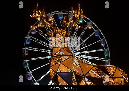Christmas Tree Wonderland, Bournemouth, Dorset UK a dicembre - scintillanti ornamenti di renne con grande ruota dietro al Pier Approach Foto Stock