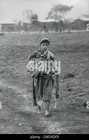 Guatemala, 1986 aprile; Una donna cammina con il suo bambino attraverso 'Central Park'. Chacaj, Huehuetenango nord-occidentale è un nuovo 'Polo di sviluppo'. Foto Stock