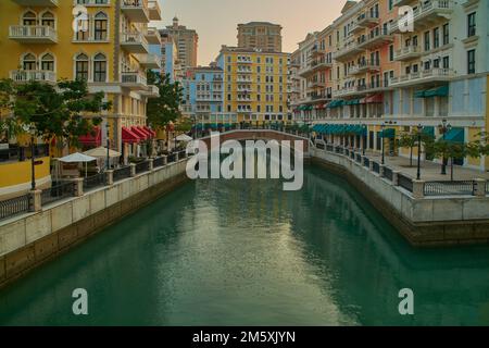 Qanat Quartier The Perla, Doha Qatar dopo mezzogiorno scatto che mostra l'architettura unica dell'edificio, canali d'acqua e visitatori Foto Stock