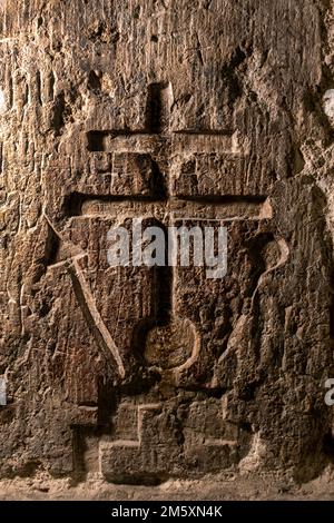 La croce patriarcale scolpita dai pellegrini medievali è incisa nel muro vicino all'ingresso della scalinata che conduce alla Cappella di San Helena nella parte inferiore della Chiesa del Santo Sepolcro nella città vecchia di Gerusalemme Est Israele Foto Stock