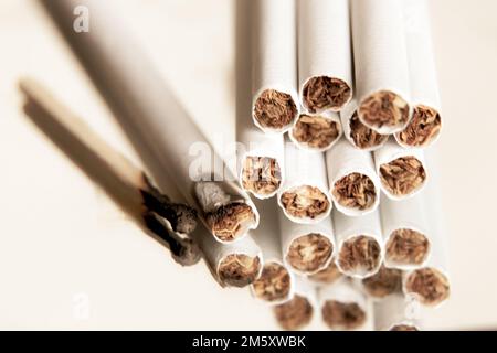 sigarette e un fiammifero bruciato su un fondo isolato, sigarette e cattive abitudini, fumo Foto Stock