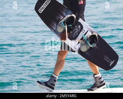 Il wakeboarder uomo porta la sua tavola Foto Stock