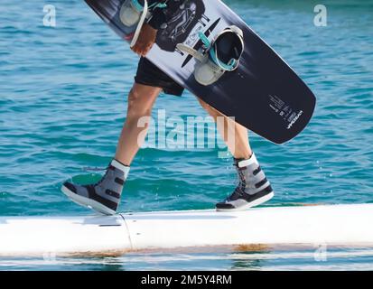 Il wakeboarder uomo porta la sua tavola Foto Stock