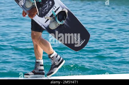 Il wakeboarder uomo porta la sua tavola Foto Stock