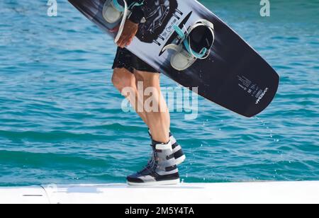 Il wakeboarder uomo porta la sua tavola Foto Stock