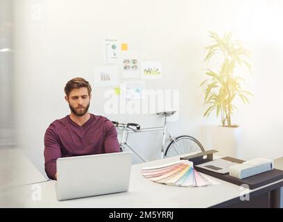 Lavorare con diligenza. un giovane architetto che lavora al suo latop. Foto Stock