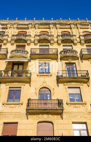 Balconi in un edificio giallo di appartamenti a San Sebastian, Spagna Foto Stock