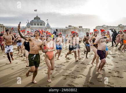 SCHEVENINGEN - la gente corre in mare sulla spiaggia di Scheveningen il giorno di Capodanno. La tradizionale immersione di Capodanno può continuare dopo due precedenti edizioni annullate a causa della crisi corona. ANP REMKO DE WAAL olanda fuori - belgio fuori Foto Stock