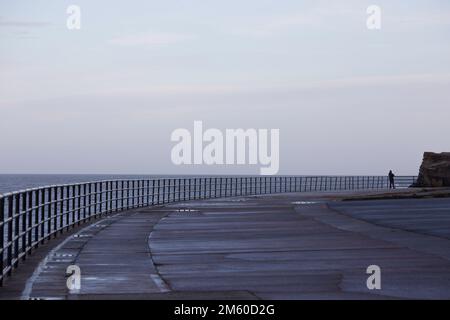 Whitley Bay Promenade in inverno con il pescatore Foto Stock