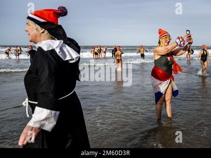 SCHEVENINGEN - la gente corre in mare sulla spiaggia di Scheveningen il giorno di Capodanno. La tradizionale immersione di Capodanno può continuare dopo due precedenti edizioni annullate a causa della crisi corona. ANP REMKO DE WAAL olanda fuori - belgio fuori Foto Stock