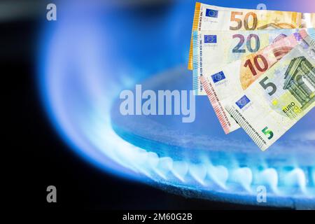 Immagine simbolica, fornello a gas, fiamma a gas, prezzo del gas, aumento del prezzo del gas, energia, costi energetici, banconote, euro Foto Stock