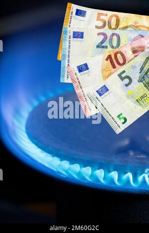 Immagine simbolica, fornello a gas, fiamma a gas, prezzo del gas, aumento del prezzo del gas, energia, costi energetici, banconote, euro Foto Stock