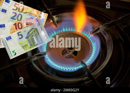 Immagine simbolica, fornello a gas, fiamma a gas, prezzo del gas, aumento del prezzo del gas, energia, costi energetici, banconote, euro Foto Stock