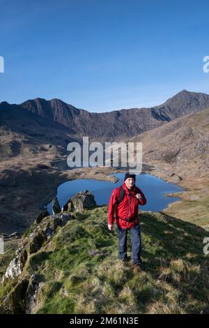 Walker at the Horns che si affaccia su CWM Dyli e Snowdon Horseshoe, Snowdonia National Park, Galles del Nord, Regno Unito Foto Stock