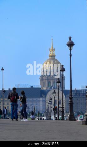 Parigi, Francia. Aprile 24. 2022. Un uomo e una donna che camminano sul famoso Pont Alexandre III Monumento storico. Hotel des Invalides sullo sfondo. Foto Stock