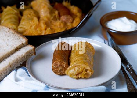 Involtini di cavolo ripieni con carne e salsiccia su un piatto. Foto Stock