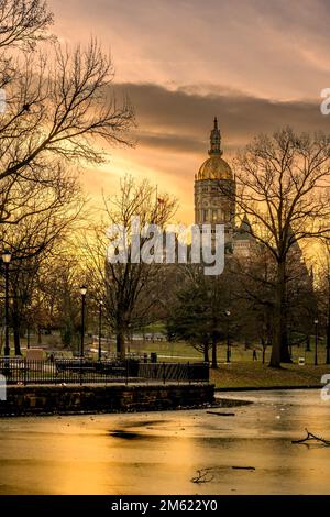 Hartford, CT - USA - 28 Dicembre 2022 Vista verticale del palazzo del governo dello Stato del Connecticut al tramonto, vista di fronte al Bushnell Park con un giglio congelato Foto Stock