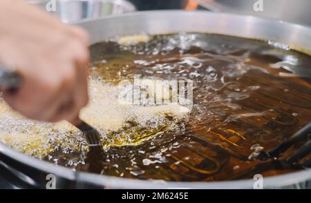 Preparazione di churros fritti con zucchero tipico della Spagna Foto Stock