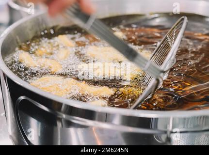 Preparazione di churros fritti con zucchero tipico della Spagna Foto Stock