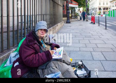 05-15-2016 Parigi Francia. Una vecchia donna (senza tetto) disegna con una penna su una strada parigina nel mese di maggio. Povertà. Foto Stock