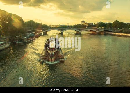 05-15-2016 Parigi Francia. Vista sul fiume Senna e sulla nave ricreativa al tramonto attraverso un bicchiere di treno Foto Stock