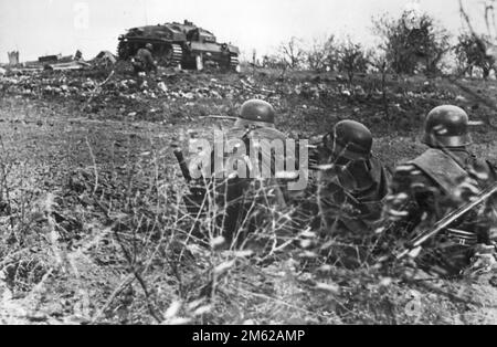 Soldati di fanteria tedeschi e una pistola semovente StuG III in una posizione di combattimento pronta ad attaccare Stalingrado durante la battaglia di Stalingrado del WW2 Foto Stock