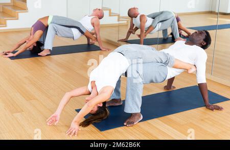 Lezioni di yoga per coppie nel moderno centro fitness Foto Stock