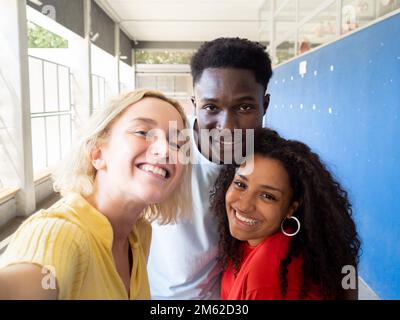 Selfie prospettiva di tre diversi studenti adolescenti che hanno un buon tempo in scuola superiore Foto Stock