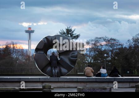 I visitatori possono ammirare il tramonto presso la statua del “Sole Nero” di Isamu Noguchi nel Parco Volontario di Seattle mentre lo Space Needle è preparato per il New Ye Foto Stock