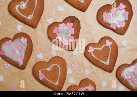 Biscotti al cuore sulla carta del panettiere. Festa della mamma. Cottura a casa. San Valentino Foto Stock