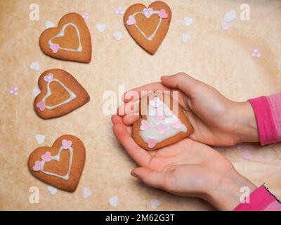 Biscotto, biscotto come cuore sulle mani del bambino. Festa della mamma. Cottura a casa. Foto Stock