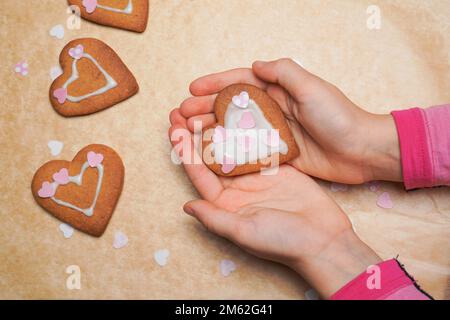 Biscotto, biscotto come cuore sulle mani del bambino. Festa della mamma. Cottura a casa. Foto Stock