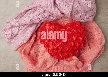 giacitura invernale con sciarpa, cuore rosso e maglione. Foto Stock