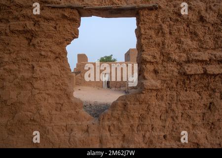 Vista di casa di adobe attraverso un foro in un muro di adobe a Timbuktu, Mali, Africa occidentale Foto Stock