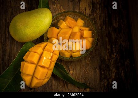mango su uno sfondo di legno scuro. Foto Stock