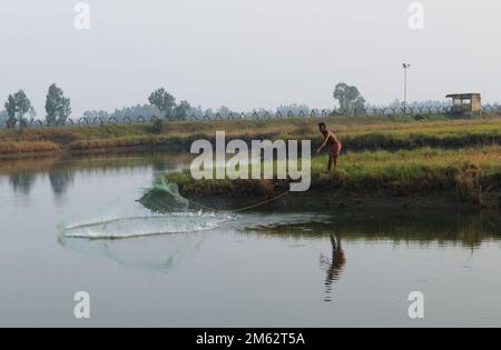 13.11.2022, bengala Occidentale, India. un pescatore indiano solitario in azione su uno stagno. Foto Stock