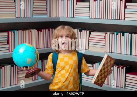 Ragazzo di scuola con mondo globo e scacchi, infanzia. Pupilla nerd. Bambino intelligente della scuola elementare con libro. Intelligenza geniale intelligente pronta per il bambino Foto Stock