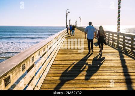 Cayucos, California, USA - 25 dicembre 2022. Un lungo molo di legno, e persone a piedi. Molo Cayucos, costa centrale della California Foto Stock