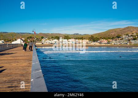 Cayucos, California, USA - 25 dicembre 2022. Un lungo molo di legno, e persone a piedi. Molo Cayucos, e vista sull'oceano, costa centrale della California Foto Stock