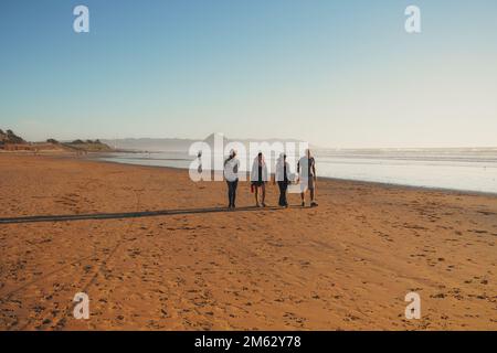 Cayucos, California, USA - 25 dicembre 2022. Ampia spiaggia di sabbia e gente che cammina lungo la riva Foto Stock