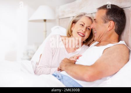 Coppia matura che tiene le mani e si guarda l'un l'altro. Ritratto di una coppia matura allegra che tiene le mani e si guarda l'un l'altro. Foto Stock