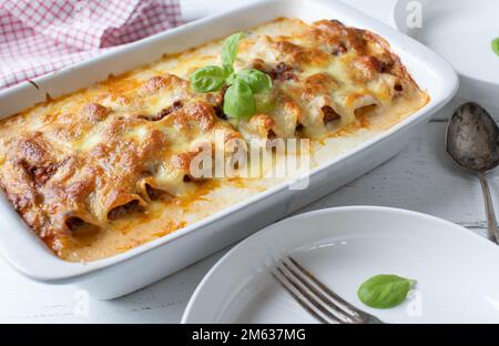 Casseruola di noodle con tagliatelle cannelloni, salsa bolognese, besciamella e mozzarella di farcitura su sfondo bianco Foto Stock