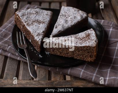 Pezzi di torta di mandorle al cioccolato su un piatto. Tradizionale torta caprese italiana. Al forno con vero cioccolato fondente e grattugiato. Foto Stock