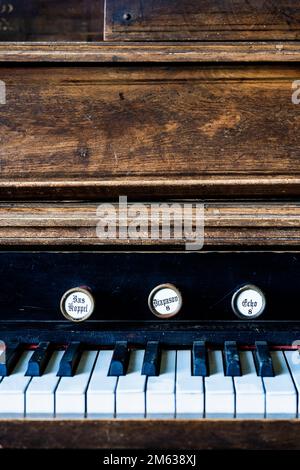 Maniglie per arresto organo su antico pianoforte in legno con tasti bianchi e neri Foto Stock