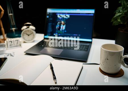 Lavorate in ufficio a casa con un computer portatile, una tazza di caffè e una lampada sulla scrivania per lavorare di notte Foto Stock